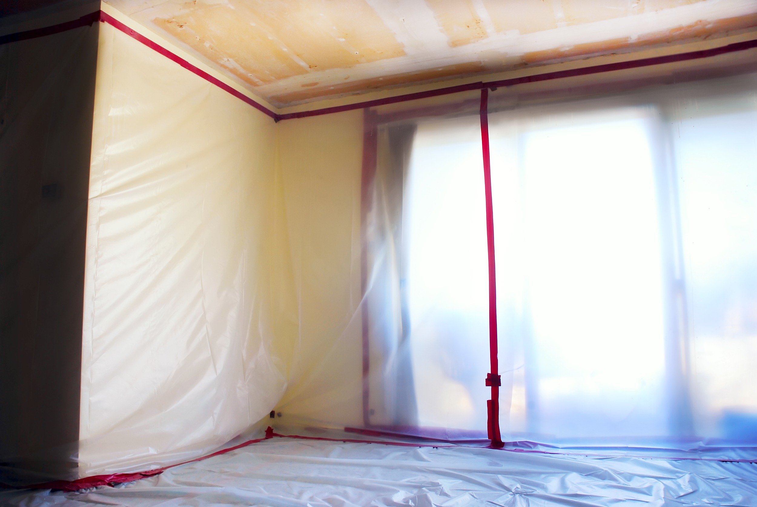 Room,Covered,With,Clear,Plastic,Sheeting,After,Asbestos,Abatement,Completed Room Covered With Plastic During a Mold Removal Job